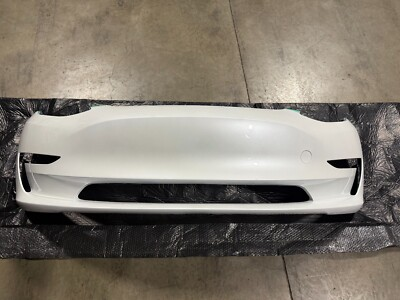 White Tesla front bumper cover resting on a protective sheet